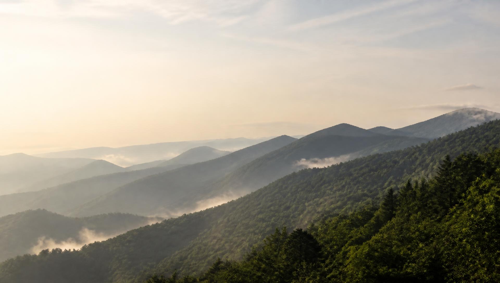 Layered mountain ridges under morning mist